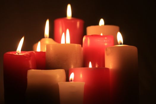 A group of burning candles in red and white