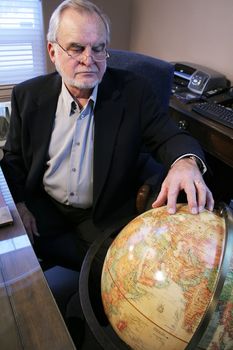 Business man pointing to European country on Globe