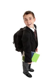 High school student carrying school bag backpack and text books.  He is in uniform, standing sideways and looking around .