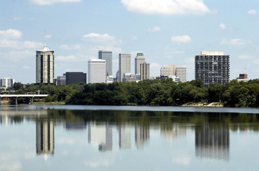 Skyline view of the city of Tulsa, Oklahoma with buildings reflected in the Arkansas River.