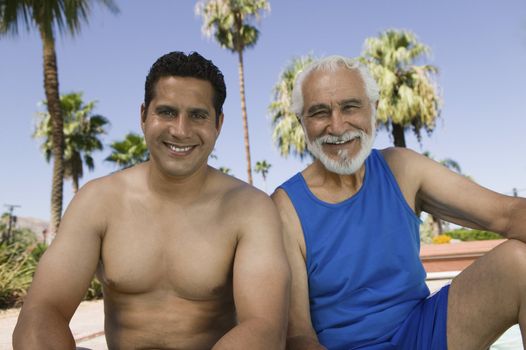 Senior Father and Son by Swimming Pool