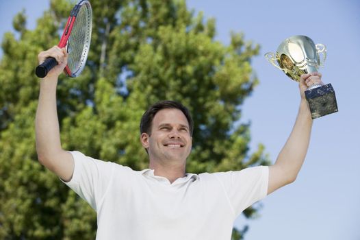Man Holding Tennis Rackets and Trophy