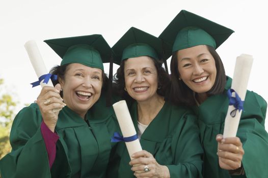 Smiling Graduates Holding Their Degrees