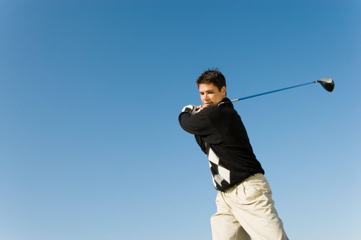 Young Man Swinging Golf Club