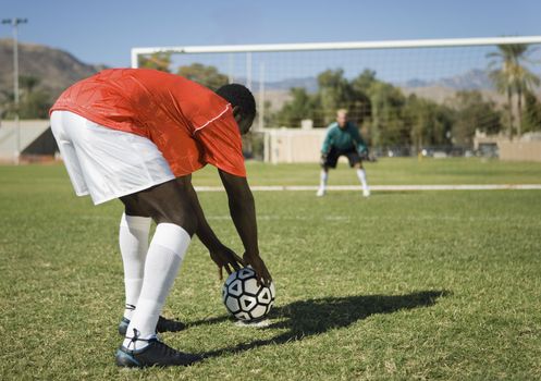 Soccer player preparing for penalty kick back view