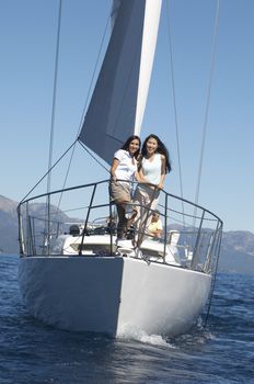 Friends Standing on Bow of Sailboat