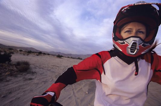 Woman in Racing Gear Riding Motorcycle
