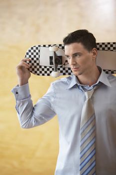 Young Businessman Holding Skateboard