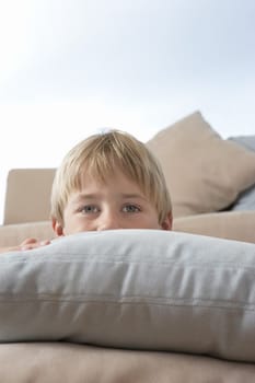 Boy Hiding Behind Pillows