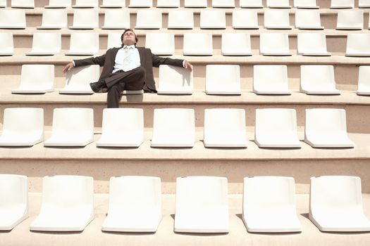 Businessman Relaxing in Auditorium