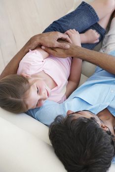 Man and Daughter Lying Down on Sofa