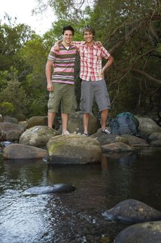 Young Hikers Standing on Rocks by Creek