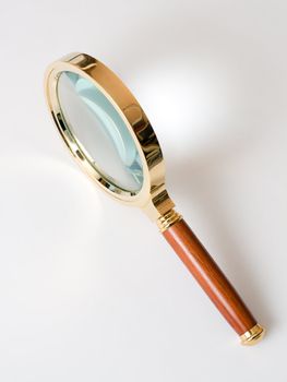 Magnifier in brass frame with a wooden handle.