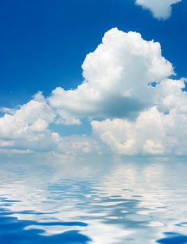 Blue sky with fluffy clouds reflected on water surface.