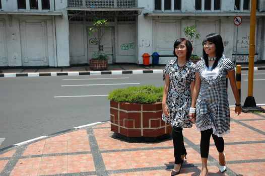 two sisters get walking together in town street 