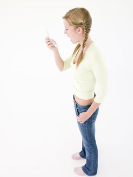 Teenage girl looking at cellular phone in shock