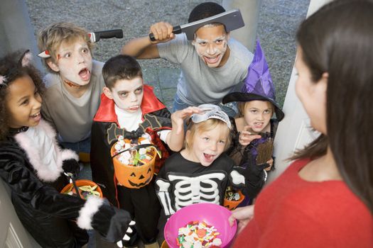 Six children in costumes trick or treating at woman's house