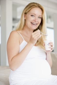 Pregnant woman with yogurt smiling