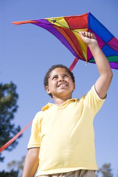 Young boy with kite outdoors smiling
