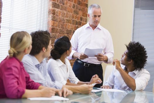 Five businesspeople in boardroom meeting