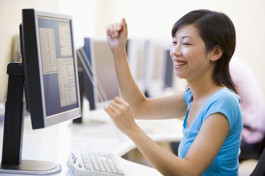 Woman in computer room cheering and smiling