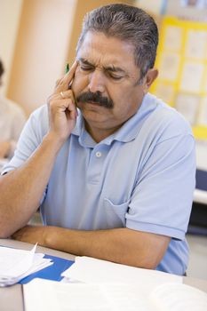 Mature male student frowning in class