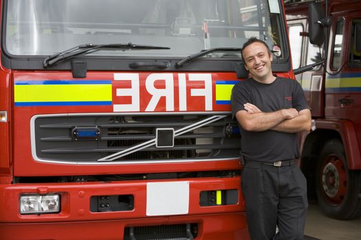 Portrait of a firefighter standing by a fire engine