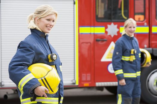 Two female firefighters by a fire engine