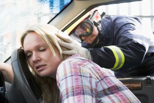 Firefighters helping an injured woman in a car