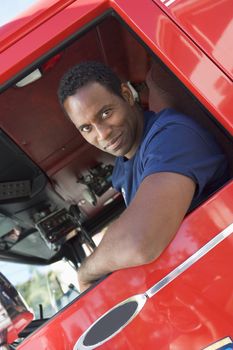 A firefighter sitting in the cab of a fire engine