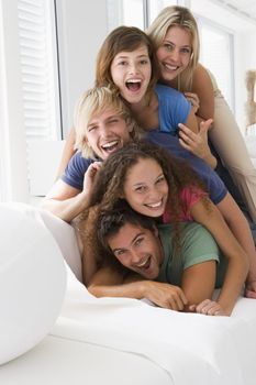 Five people in living room piled up smiling