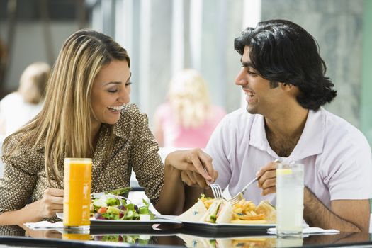 Couple at restaurant eating and smiling
