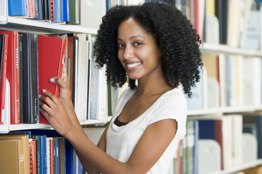 University student selecting book in library