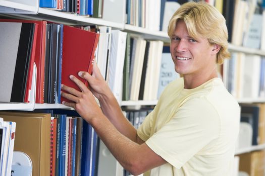 University student selecting book from library