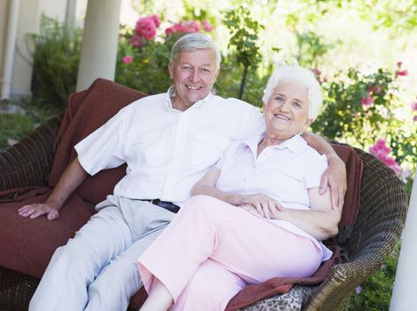 Senior couple relaxing on garden seat