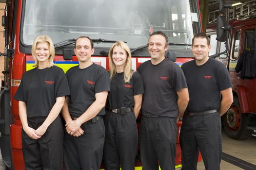 Five firefighters standing in front of fire engine 