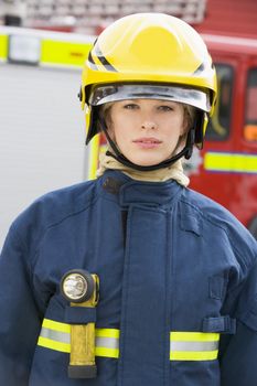 Firewoman standing by fire engine 