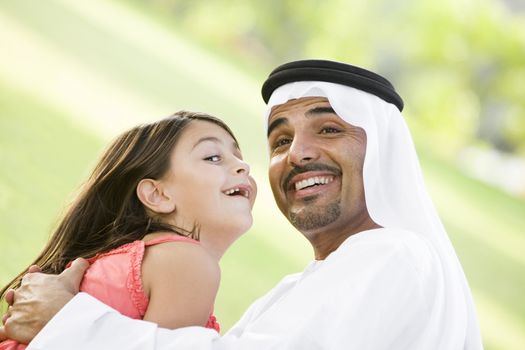Man and young girl outdoors in park playing and smiling (selective focus) 