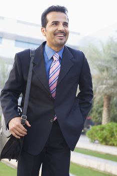 Businessman walking outdoors smiling (high key/selective focus) 