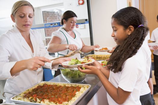 Students in cafeteria line being served lunch