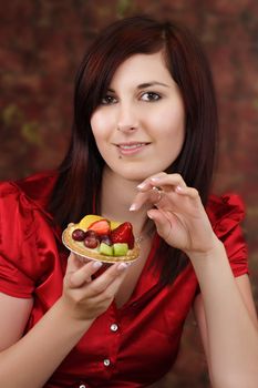 woman holding a fruit tartlet