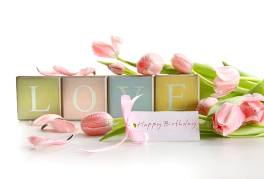 Wooden blocks with tulips and gift card on white
