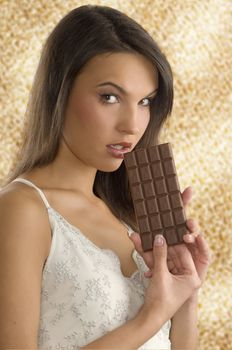 brunette eating a block of chocolate with a white dress