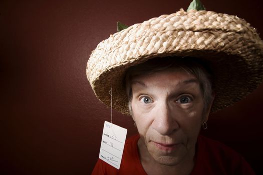 Senior woman in a cheap straw hat