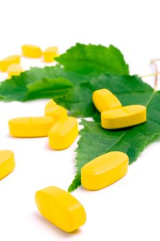 vitamin pills over green leaves