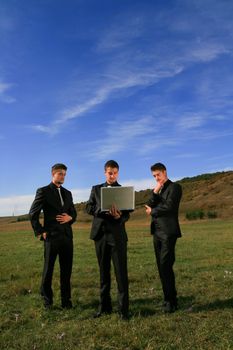 Group of business men watching laptop