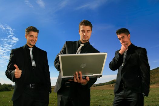 Group of business men watching laptop