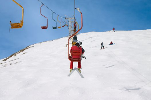 skiers on chair lift in the winter mountains