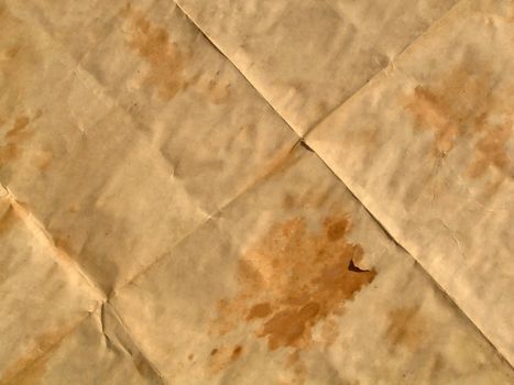 Piece of an old brown paper with wet spots which has been combined by squares.