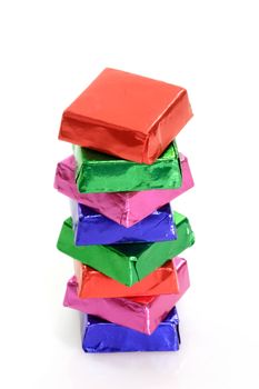 Stack of wrapped chocolate blocks on bright background